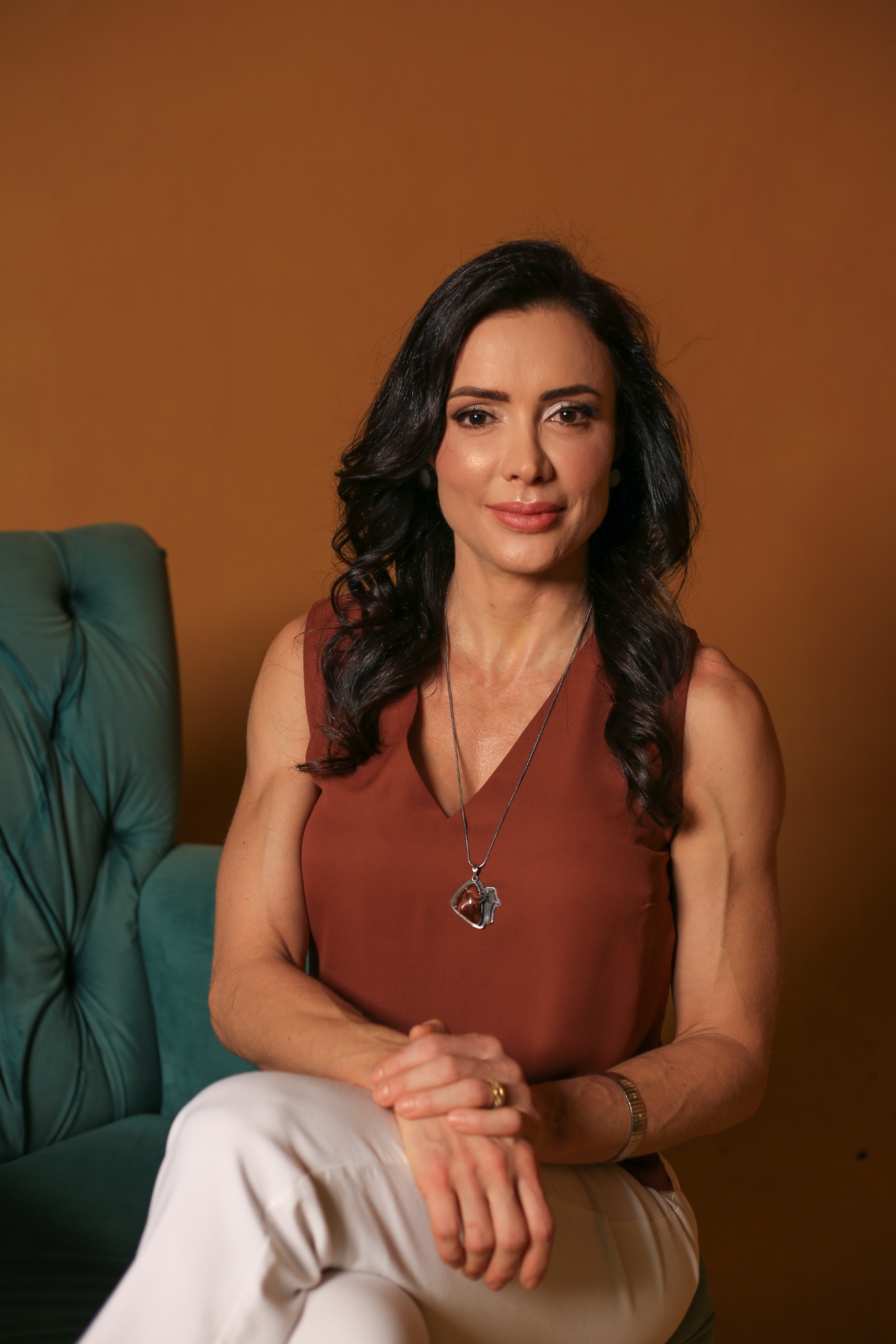 Dra. Mônica Bergamo sentada, em um retrato profissional